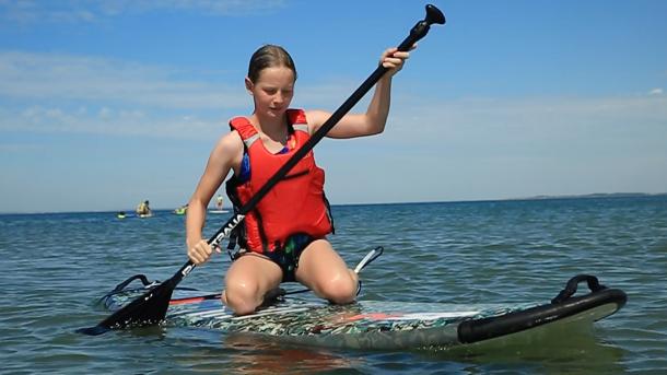 Pige siddende på SUP board ved Bagenkop