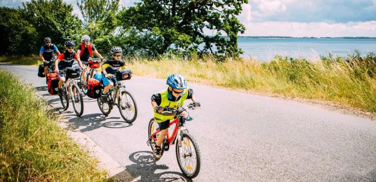 Familie cykler på vej langs vandet