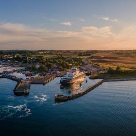 Aerial view of a ferry having just entered Spodsbjerg Harbour, Langeland on a sunny evening.